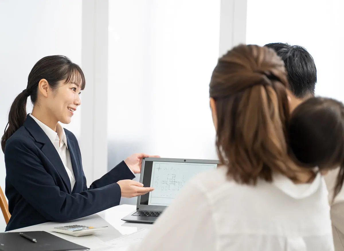 タブレットで説明する女性スタッフと家族の様子