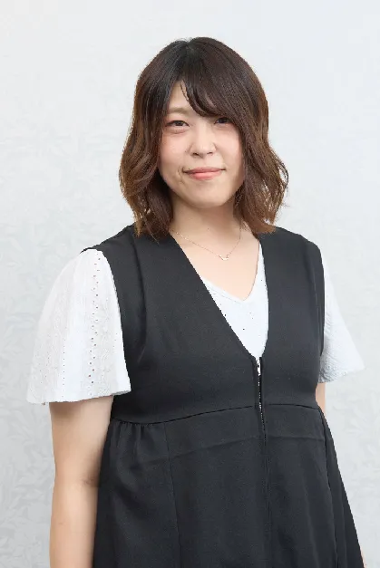 スーツを着た男性スタッフが笑顔で立っている写真